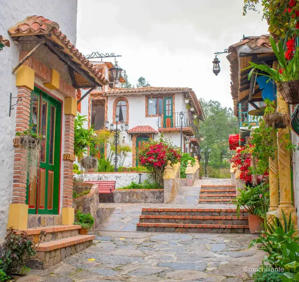 Calle colonial del Pueblito Boyacense con casas blancas, tejas y flores