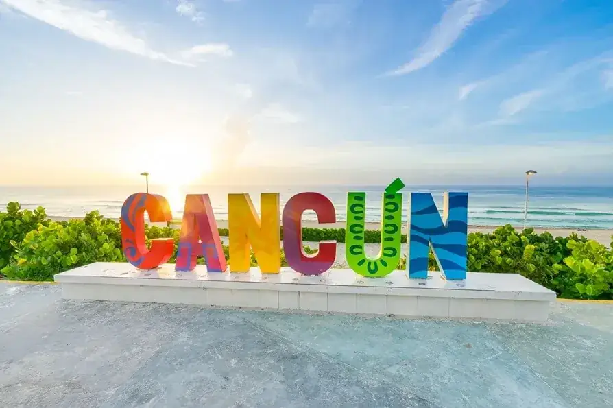 Letrero de Cancún frente a la playa y el mar Caribe