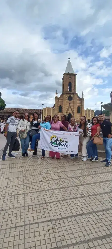 Viajeros con el pendón de Cacique Kaahele frente a una iglesia colonial